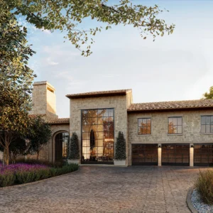 A beautiful stone house with large windows, a brown tiled roof, and a wide driveway.