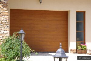 A brown wooden garage door with horizontal lines, next to a decorative stone wall and a lantern.