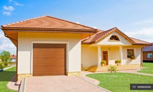 A modern house with a brown garage door and decorative plants by the entrance.